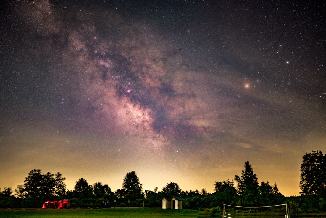 Cameras can be modified to increase their sensitivity to certain bands or wavelengths of light, like Hα. This composite of two-minute sky and ground exposures was taken with such a camera at ISO 400, and reveals clouds of hydrogen gas set aglow by the radiation of young, forming stars.