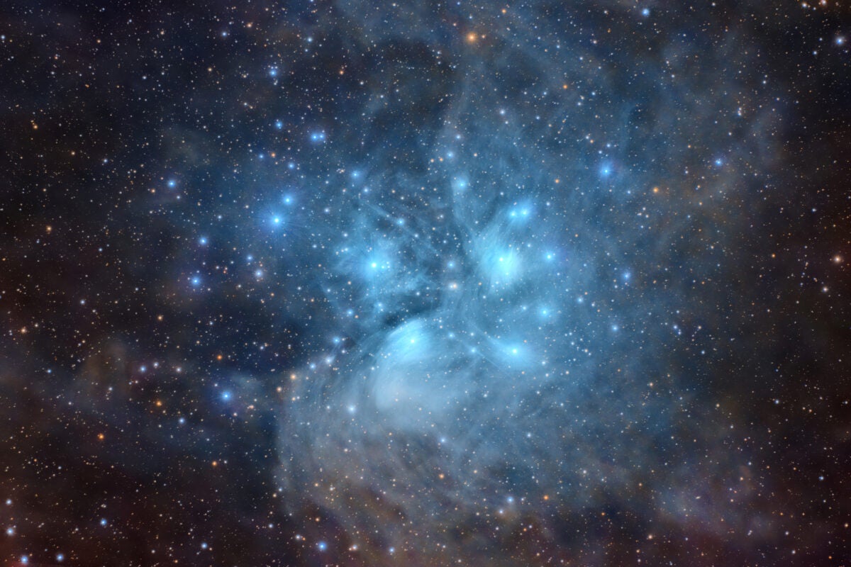 The Pleiades (M45) is an open star cluster in Taurus surrounded by a reflection nebula. The cluster is composed of more than a thousand stars but is mostly known for a handful of dominating stars, earning M45 the nickname Seven Sisters. 