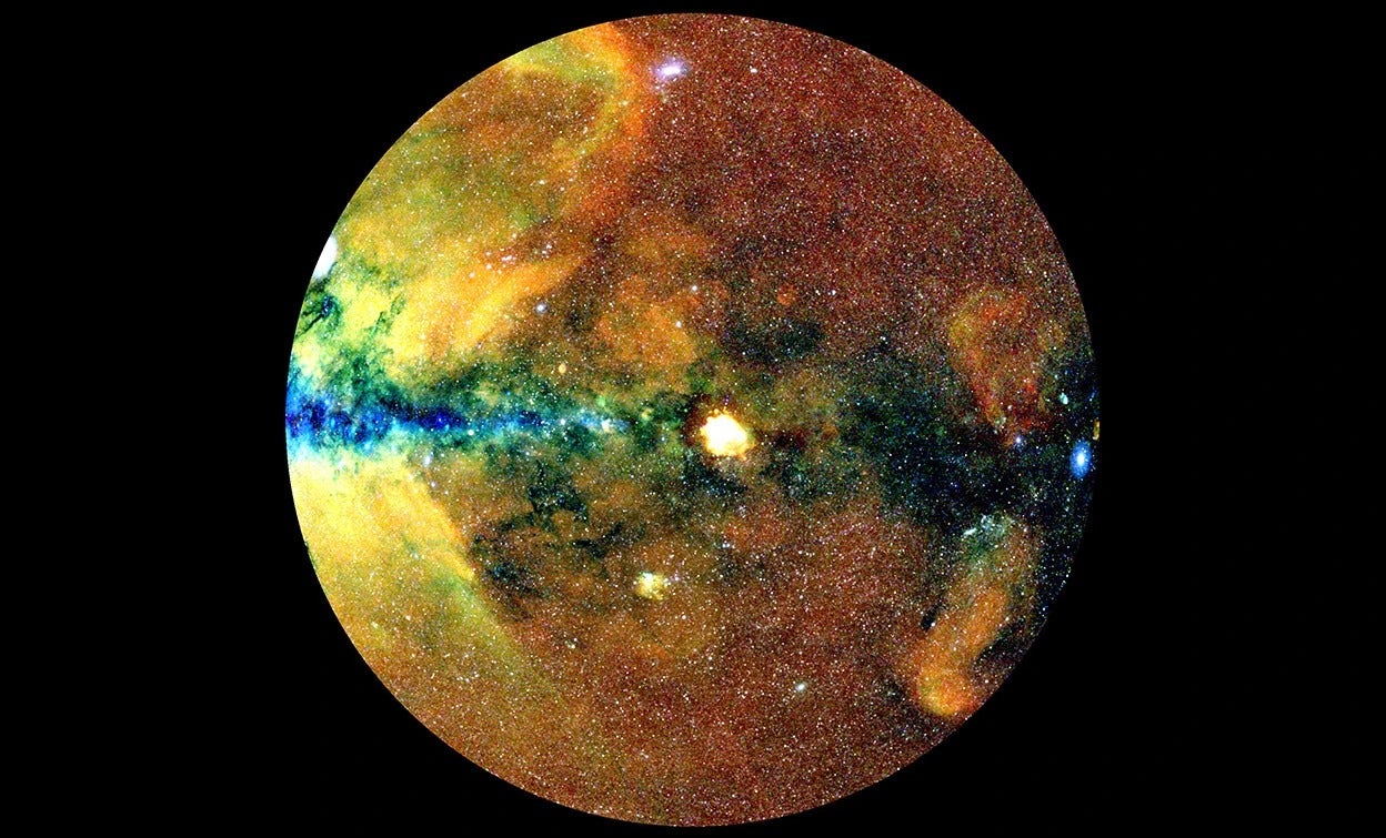 A map of the celestial hemisphere compiled from data from the eROSITA telescope — the colors reflect the wavelengths of X-rays. Hot gas haloes surrounding galaxy clusters have broad-band emissions (white), as do black holes (white dots); diffuse emissions have long wavelengths (red); and in the central regions of the Milky Way, dust blocks longer-wavelength emissions, so that only short-wavelength X-rays are visible (blue or black).